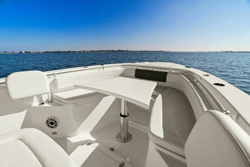  Yacht Photos Pics 2023 Cobia 301 Center Console boat interior with seating and table, ocean view.