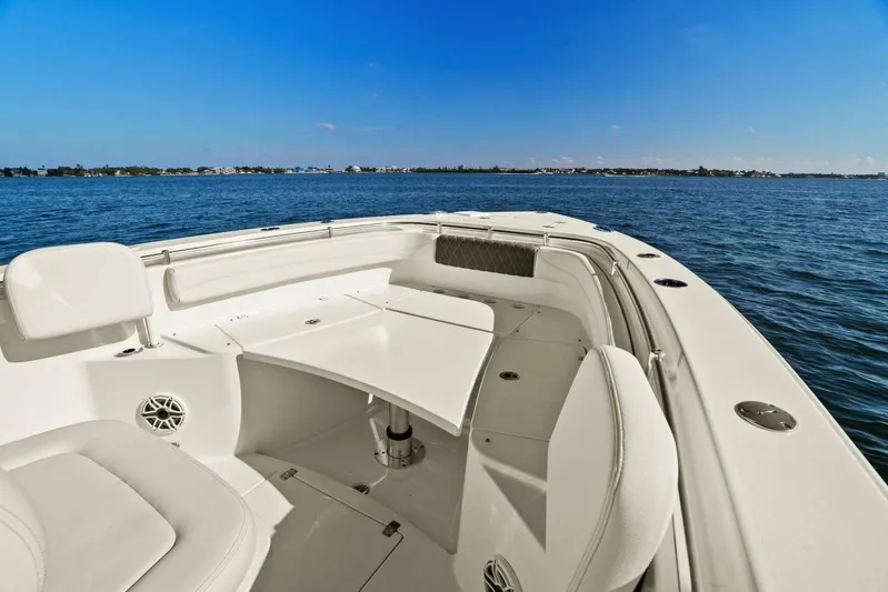  Yacht Photos Pics 2023 Cobia 301 Center Console boat on calm blue waters, featuring spacious seating.