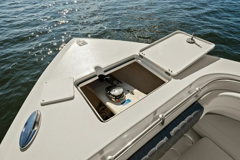 Yacht Photos Pics 2023 Cobia 301 Center Console boat with open storage compartment on calm water.