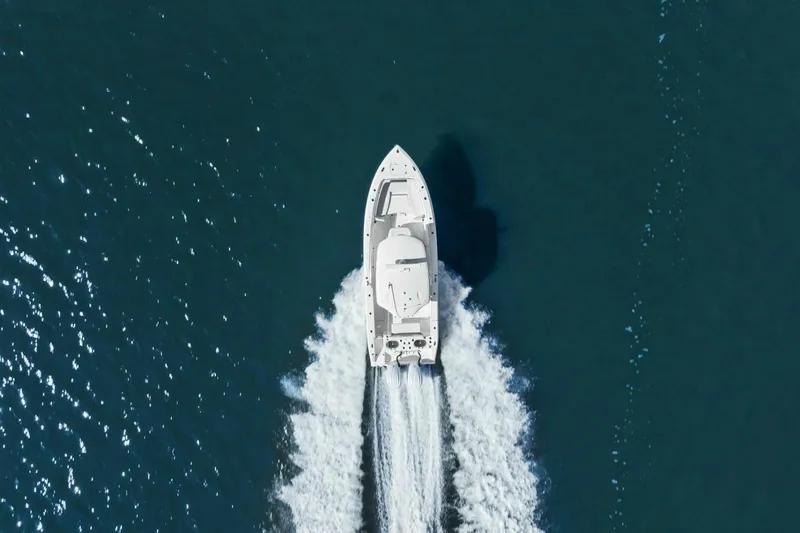  Yacht Photos Pics Aerial view of 2023 Cobia 301 Center Console boat cruising on open water.