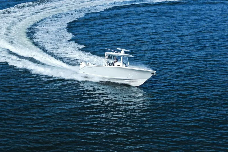  Yacht Photos Pics 2023 Cobia 301 Center Console boat cruising on open water.