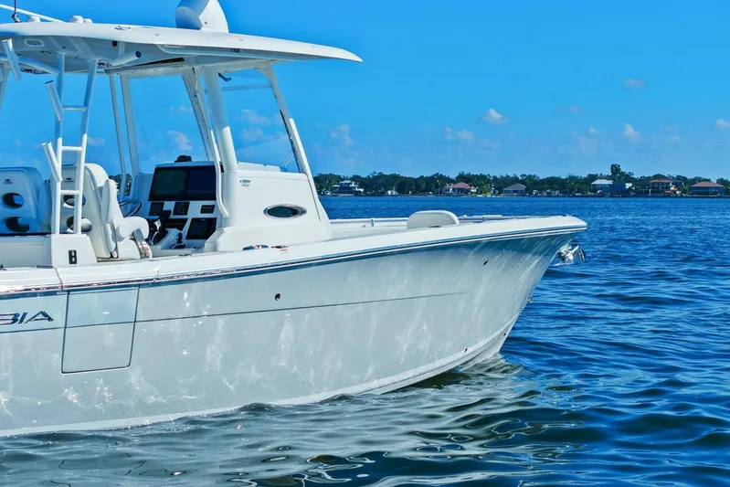  Yacht Photos Pics 2023 Cobia 301 Center Console boat on calm blue water under clear sky.