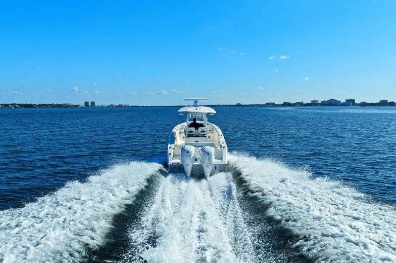  Yacht Photos Pics 2023 Cobia 301 Center Console boat cruising on open water under clear blue sky.