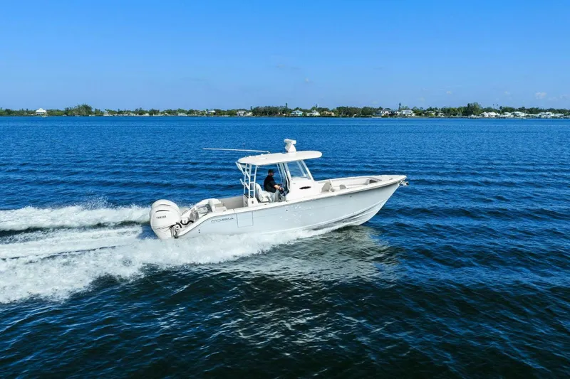  Yacht Photos Pics 2023 Cobia 301 Center Console boat cruising on open water.
