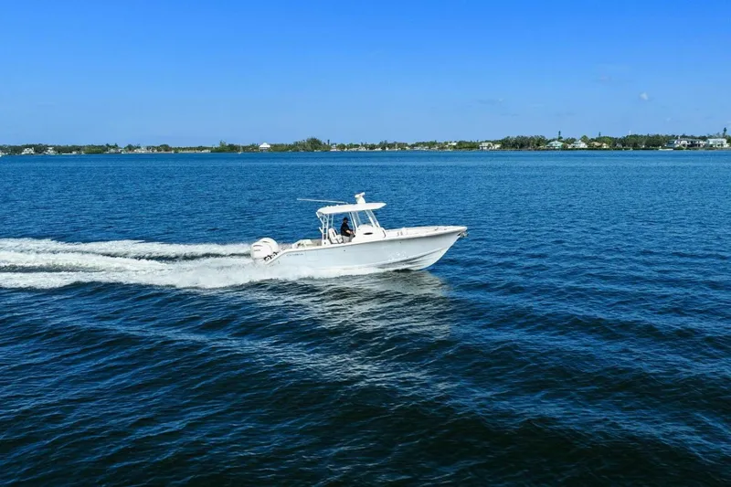  Yacht Photos Pics 2023 Cobia 301 Center Console boat cruising on open water under clear blue sky.