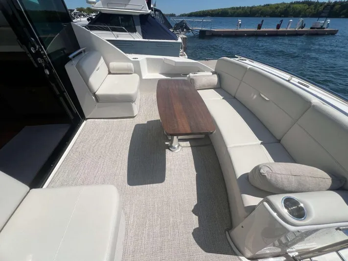 Yacht Photos Pics 2022 Tiara Yachts C44 Coupe with spacious outdoor seating and table on deck.