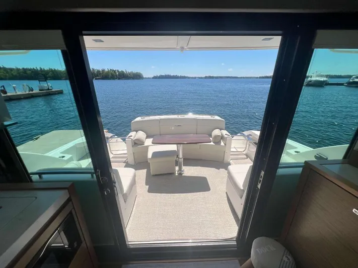  Yacht Photos Pics 2022 Tiara Yachts C44 Coupe interior with open deck view of serene waters.