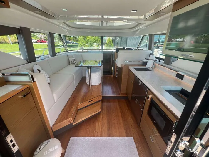  Yacht Photos Pics Interior of 2022 Tiara Yachts C44 Coupe, featuring modern kitchen and seating area.