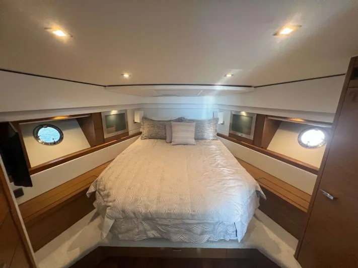  Yacht Photos Pics Luxurious bedroom interior of 2022 Tiara Yachts C44 Coupe with elegant bedding and porthole windows.