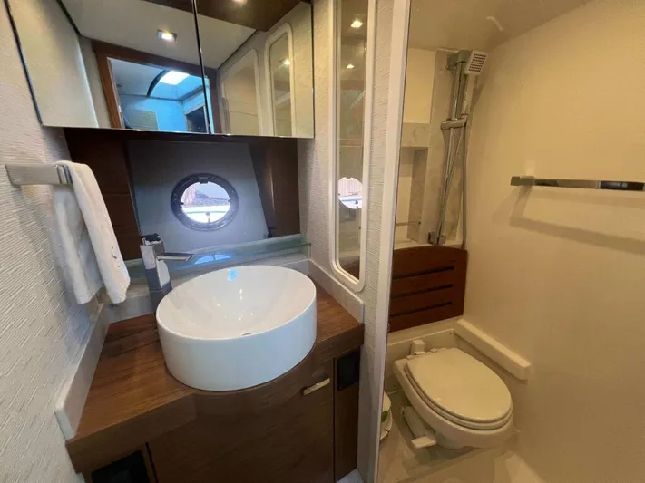  Yacht Photos Pics Luxurious bathroom in 2022 Tiara Yachts C44 Coupe with modern fixtures and porthole window.