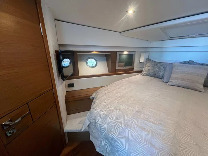  Yacht Photos Pics 2022 Tiara Yachts C44 Coupe bedroom with modern design and cozy bedding.