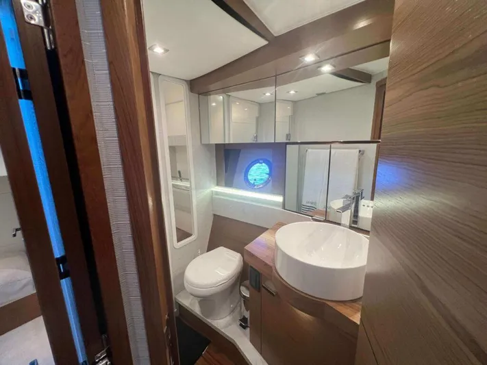  Yacht Photos Pics Luxurious bathroom in 2022 Tiara Yachts C44 Coupe with modern fixtures and porthole window.