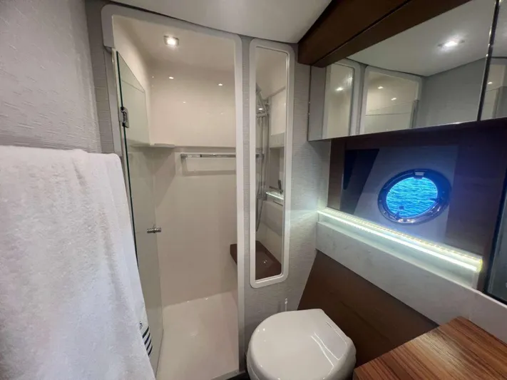  Yacht Photos Pics Luxurious bathroom in 2022 Tiara Yachts C44 Coupe with modern fixtures and porthole window.