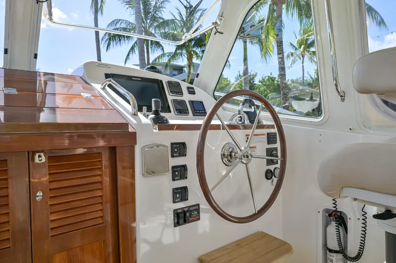 Euphony Yacht Photos Pics 2013 MJM 36z Downeast boat helm with wooden accents and palm trees in the background.