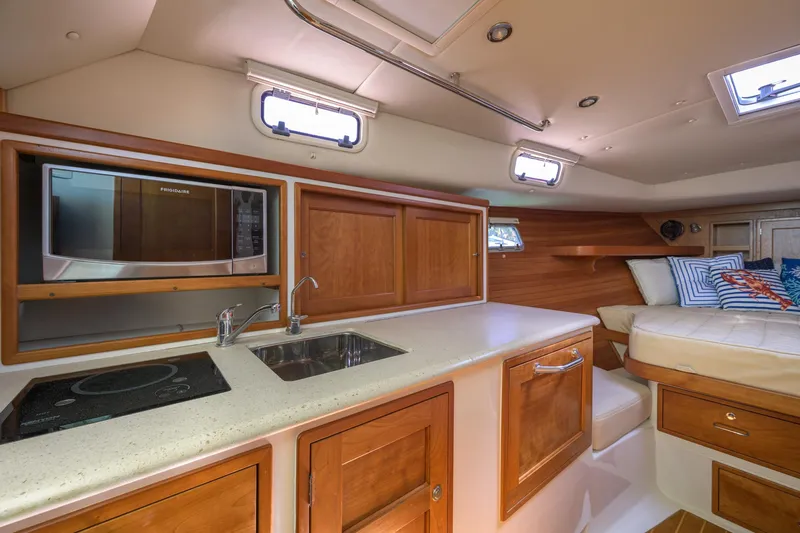 Euphony Yacht Photos Pics 2013 MJM 36z Downeast yacht interior with kitchenette, sink, and cozy seating area.