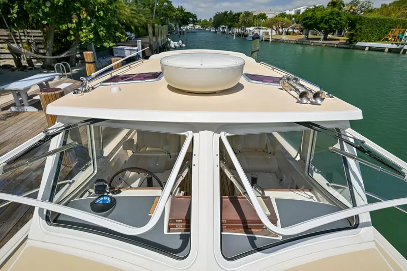 Euphony Yacht Photos Pics 2013 MJM 36z Downeast boat on a serene waterway, showcasing its sleek design and open windows.