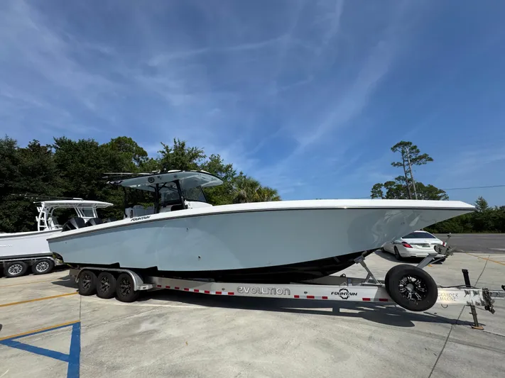  Yacht Photos Pics 2022 Fountain 38TE boat on trailer, parked outdoors under clear blue sky.