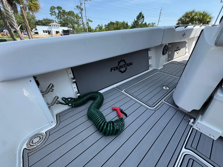  Yacht Photos Pics 2022 Fountain 38TE boat deck with coiled green hose and sleek design.