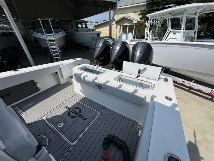 Yacht Photos Pics 2022 Fountain 38TE boat interior with triple Mercury engines, docked in a marina.