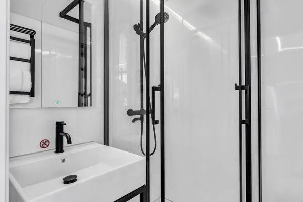  Yacht Photos Pics Modern bathroom with sleek black fixtures, glass shower, and white sink. La Mare Modern 11, 2024.