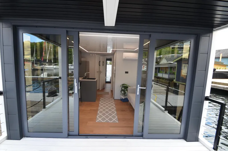  Yacht Photos Pics Modern La Mare houseboat interior with glass doors, sleek design, and waterfront view, 2024 model.