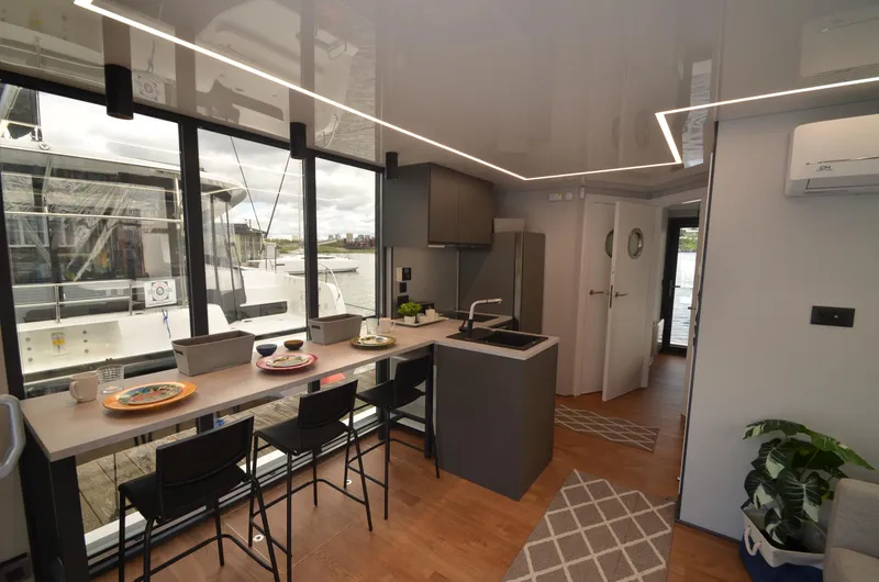  Yacht Photos Pics Modern houseboat interior with sleek kitchen, dining area, and large windows. La Mare Modern 11, 2024.