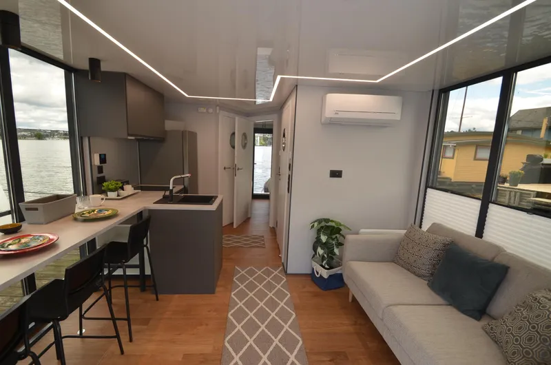  Yacht Photos Pics Modern 2024 La Mare houseboat interior with sleek kitchen, cozy living area, and waterfront views.
