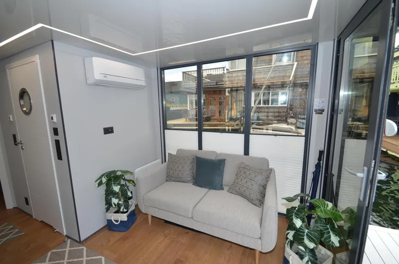  Yacht Photos Pics Modern living room in La Mare Modern 11 houseboat, 2024, with sofa and large windows.