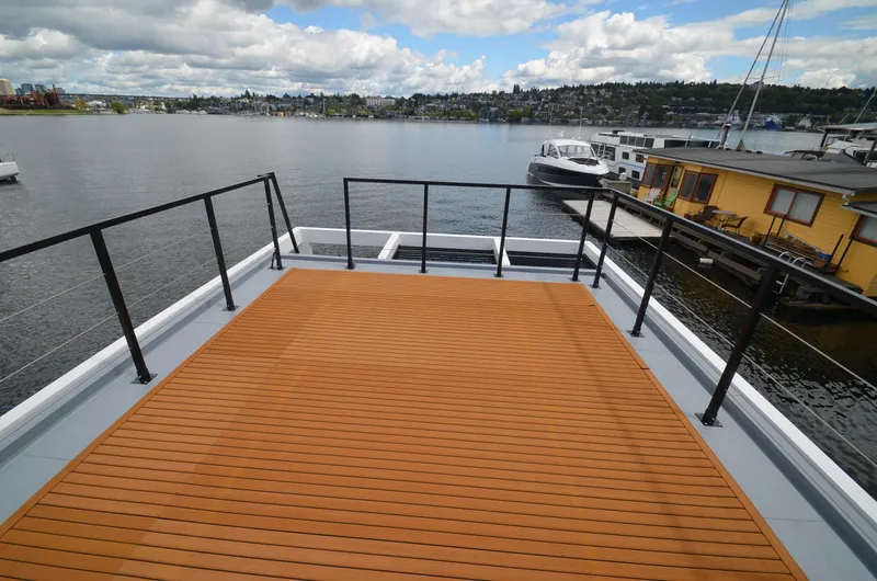  Yacht Photos Pics Rooftop deck of 2024 La Mare Modern 11 houseboat overlooking a scenic waterfront.