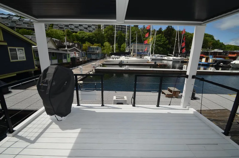  Yacht Photos Pics Modern La Mare houseboat deck overlooking marina with sailboats, 2024 model.