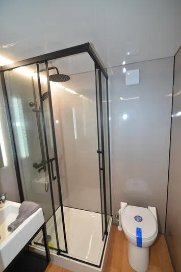  Yacht Photos Pics Modern bathroom with glass shower, sleek sink, and toilet in La Mare Modern 11, 2024 model.