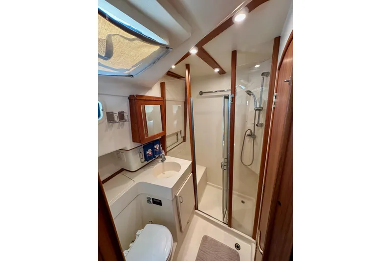 Ripple Yacht Photos Pics Luxurious bathroom in 2000 Mainship 390 Trawler with shower and wooden accents.