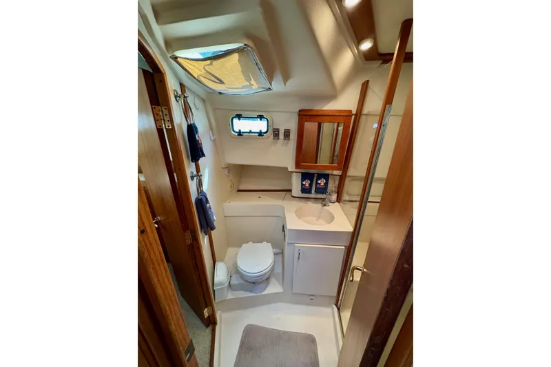 Ripple Yacht Photos Pics Bathroom interior of 2000 Mainship 390 Trawler with sink, toilet, and wooden accents.