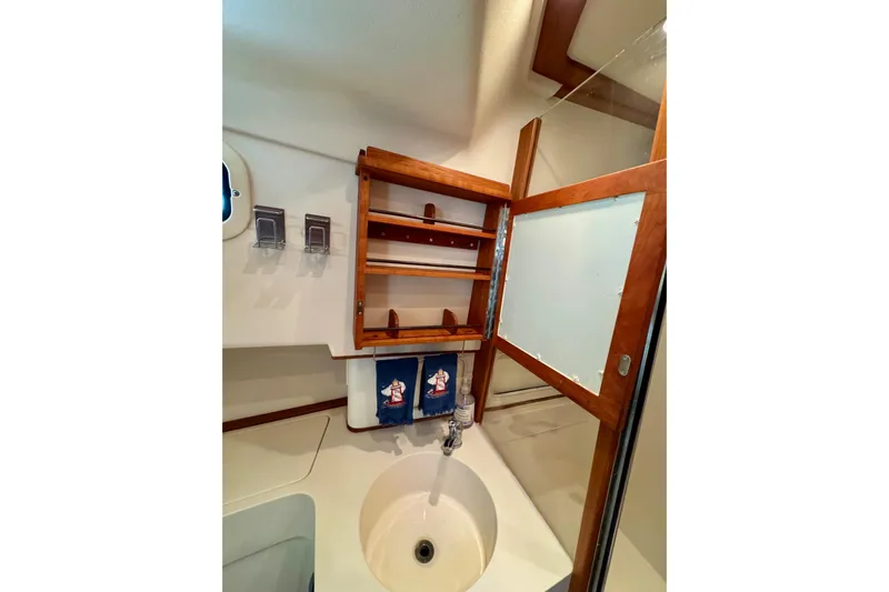 Ripple Yacht Photos Pics Bathroom interior of 2000 Mainship 390 Trawler with wooden cabinet and sink.