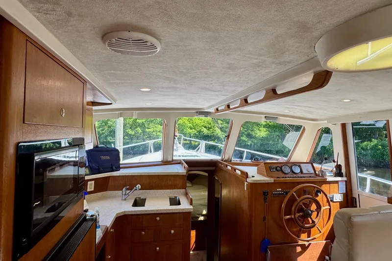 Ripple Yacht Photos Pics Interior of 2000 Mainship 390 Trawler with wooden cabinetry and helm station.