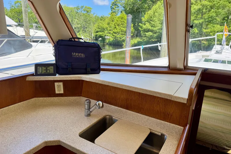 Ripple Yacht Photos Pics Interior of 2000 Mainship 390 Trawler with sink, clock, and bag on counter.