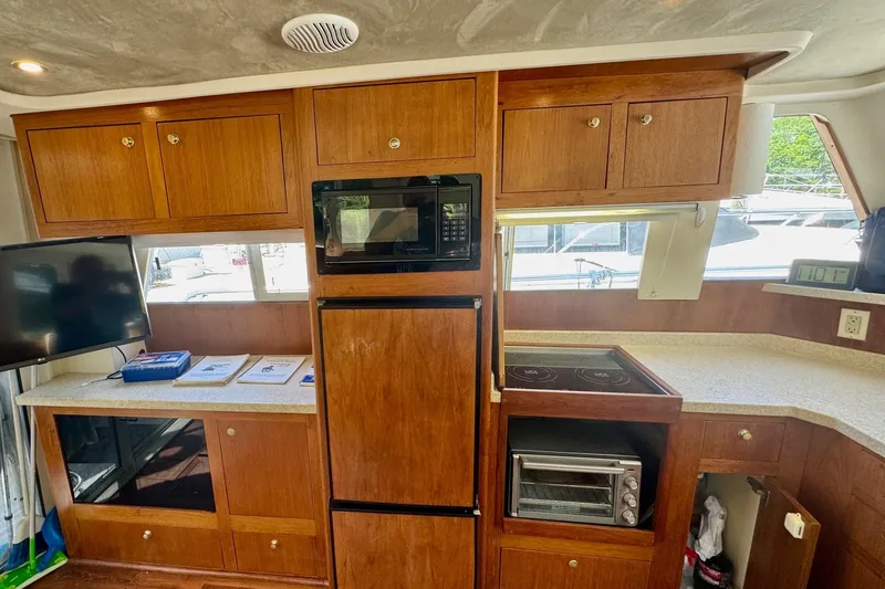 Ripple Yacht Photos Pics 2000 Mainship 390 Trawler interior with kitchen, microwave, stove, and wooden cabinetry.
