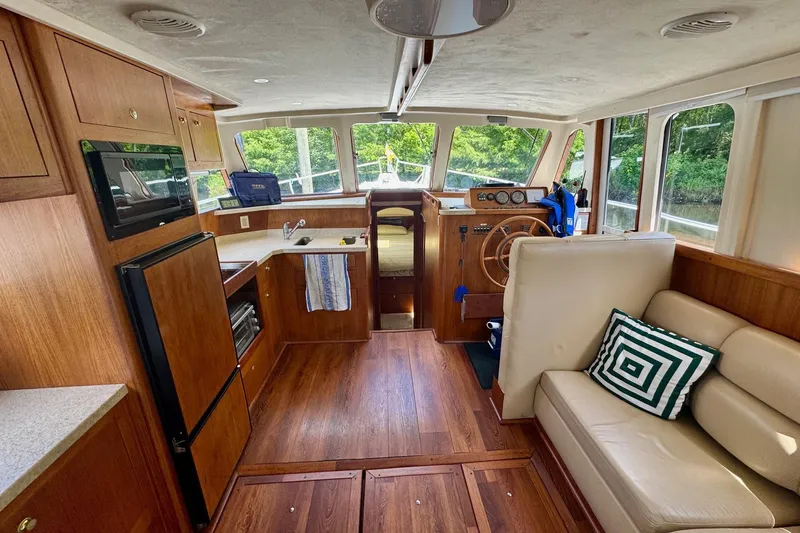 Ripple Yacht Photos Pics 2000 Mainship 390 Trawler interior with wood finish, kitchenette, and seating area.