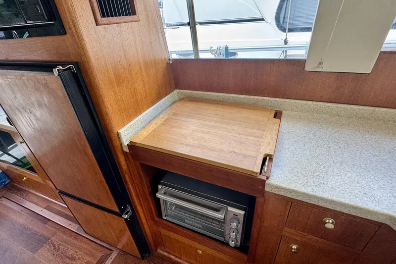Ripple Yacht Photos Pics 2000 Mainship 390 Trawler kitchen with wooden cutting board and compact oven.