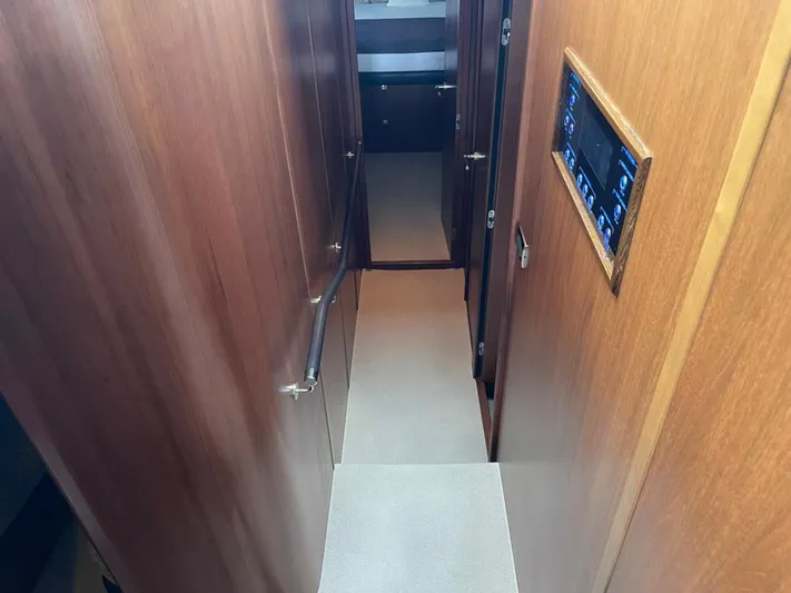  Yacht Photos Pics Interior hallway of 2013 Princess 72 Motor Yacht with wooden paneling and control panel.