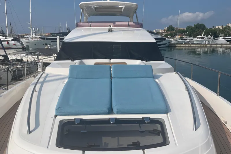  Yacht Photos Pics 2013 Princess 72 Motor Yacht with blue sunbeds docked in a marina.