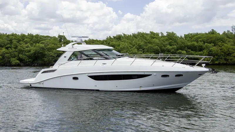  Yacht Photos Pics 2015 Sea Ray 450 Sundancer yacht cruising on a calm river with lush greenery.