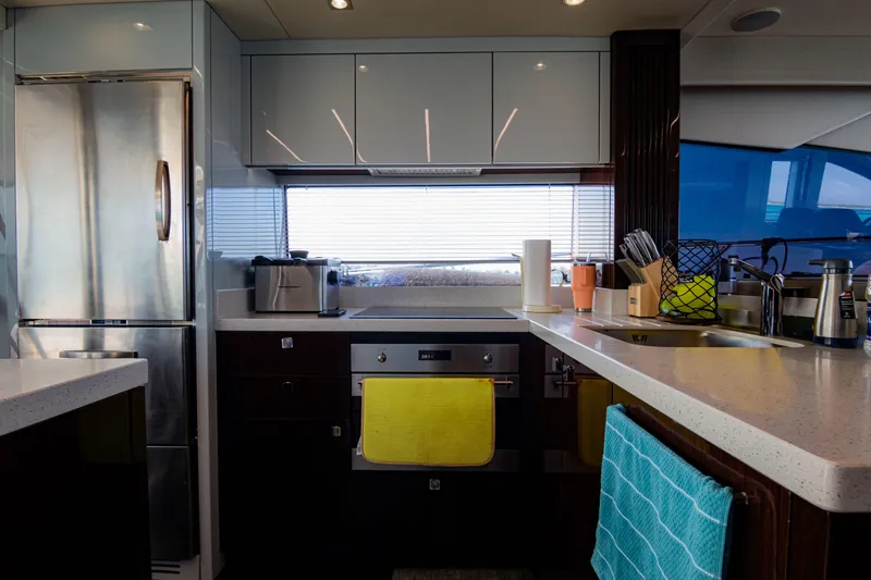 O Legasea Yacht Photos Pics Modern kitchen interior of 2018 Sunseeker Manhattan 66 yacht, featuring sleek appliances and countertops.