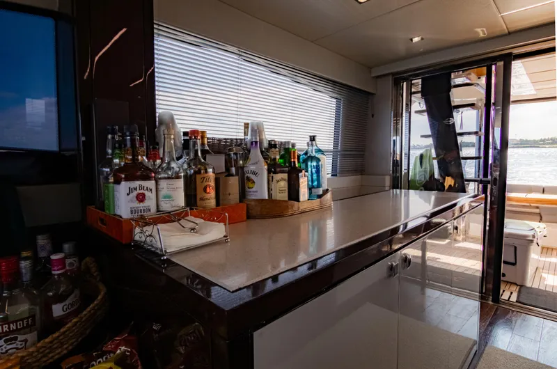 O Legasea Yacht Photos Pics Luxurious bar area on 2018 Sunseeker Manhattan 66 yacht with assorted beverages.