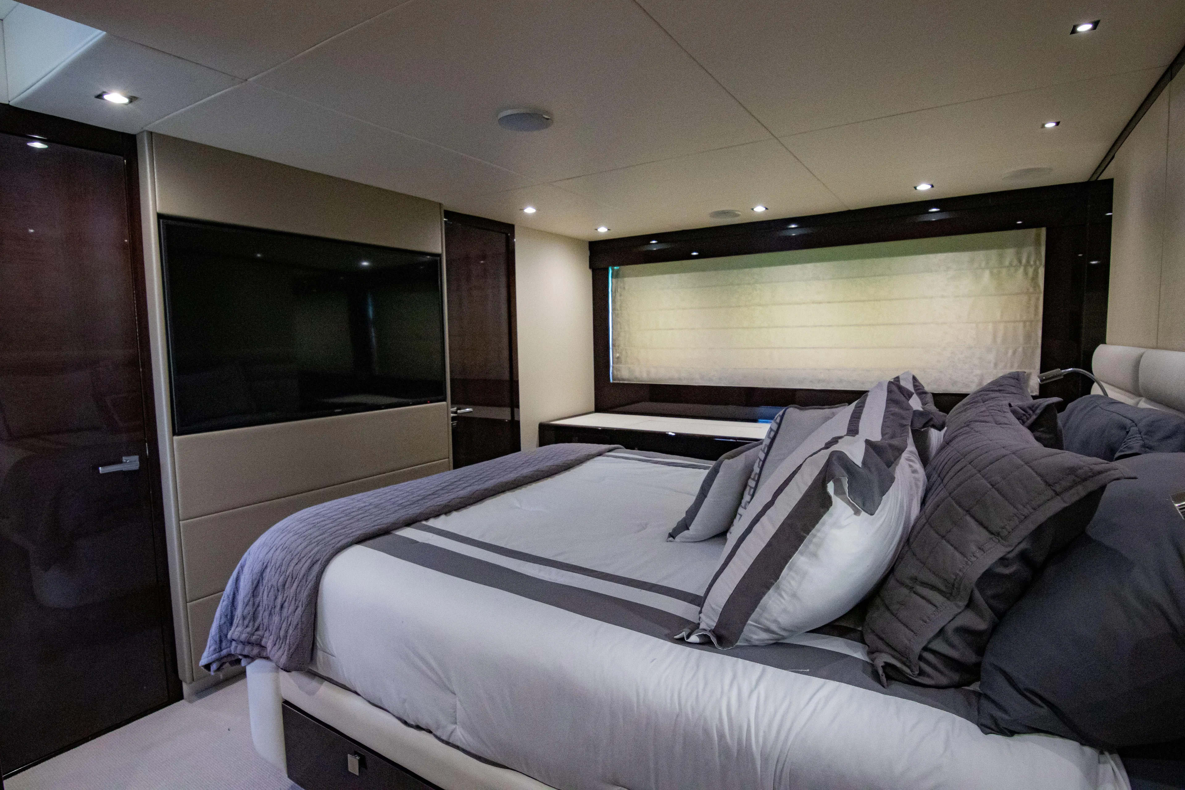 O Legasea Yacht Photos Pics Luxurious bedroom interior of 2018 Sunseeker Manhattan 66 yacht, featuring modern design and elegant furnishings.