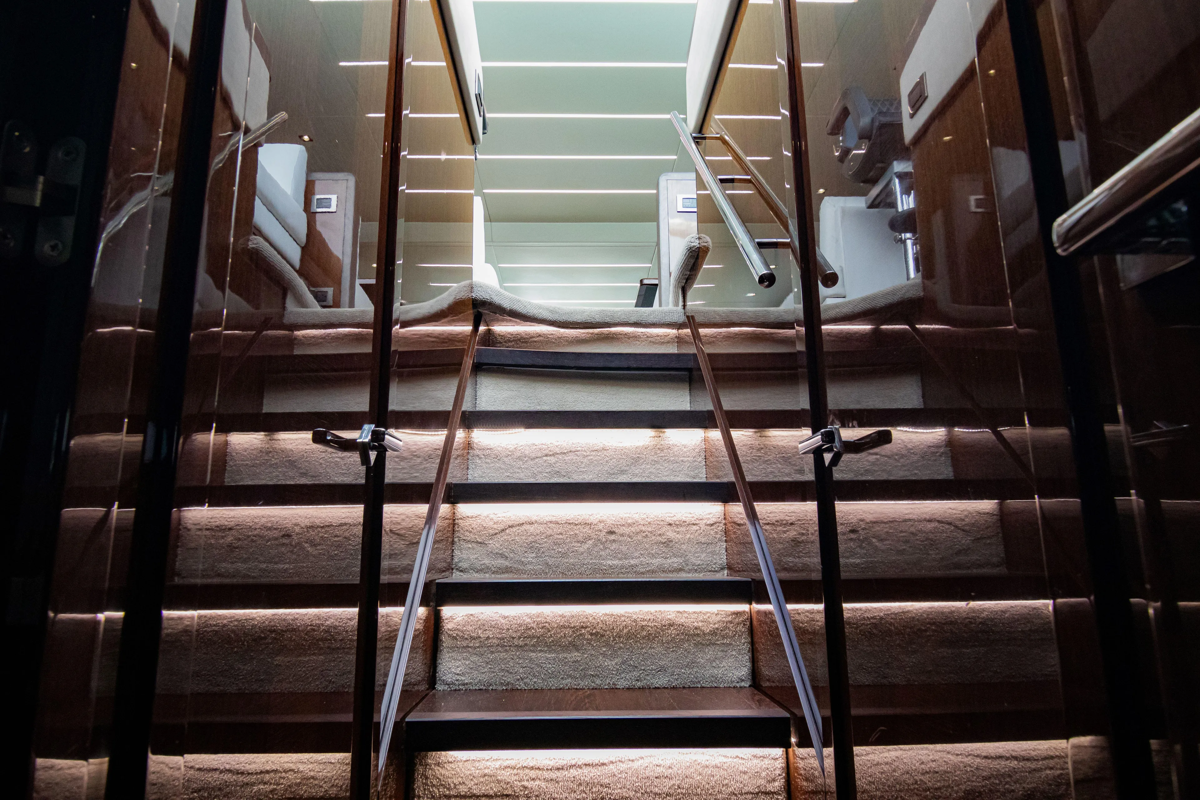 O Legasea Yacht Photos Pics Luxurious interior staircase of 2018 Sunseeker Manhattan 66 yacht, featuring elegant lighting.