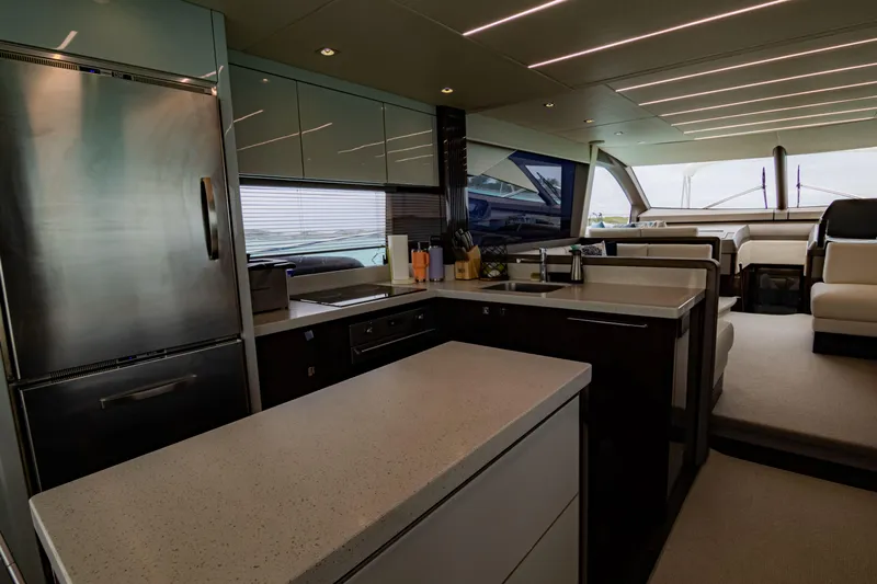 O Legasea Yacht Photos Pics Luxurious interior of 2018 Sunseeker Manhattan 66 yacht, featuring modern kitchen and seating area.