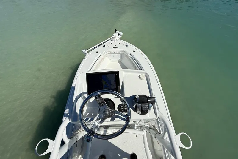  Yacht Photos Pics 2017 Yellowfin 26 Hybrid boat dashboard with steering wheel and controls on calm water.