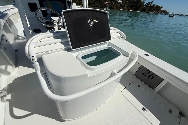  Yacht Photos Pics 2017 Yellowfin 26 Hybrid boat interior with open storage compartment, steering wheel, and water view.