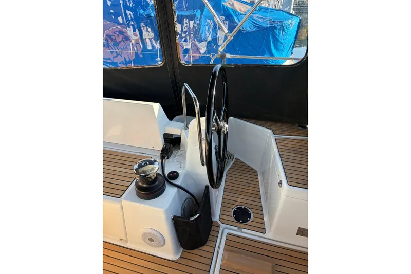 Atticus Yacht Photos Pics Cockpit of 2022 Jeanneau Sun Odyssey 490 sailboat with steering wheel and teak flooring.